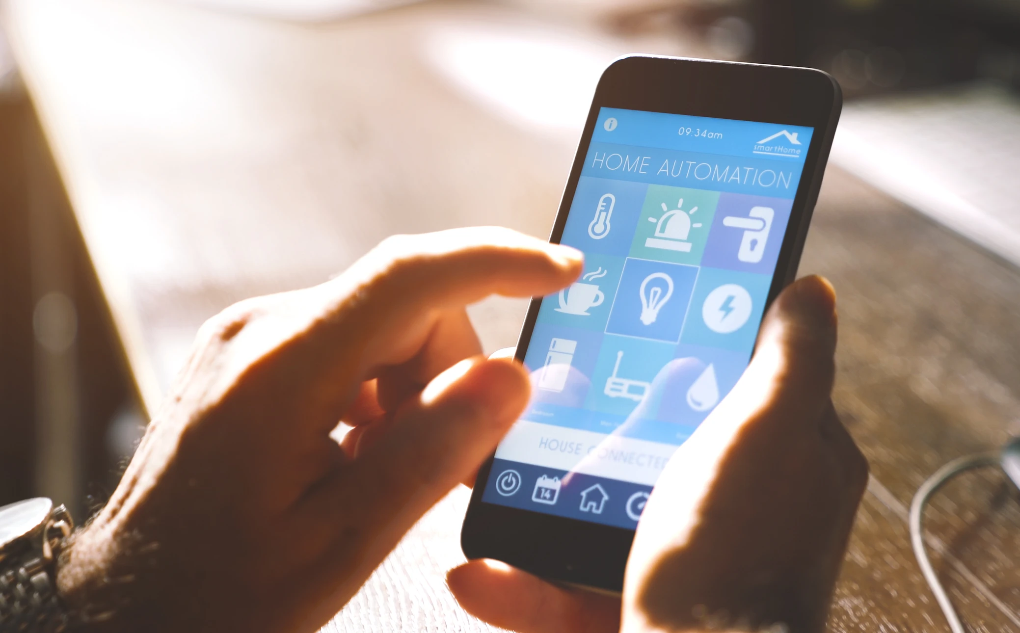 Intérieur éclairé par lumière naturelle, personne utilisant smartphone pour contrôler domotique