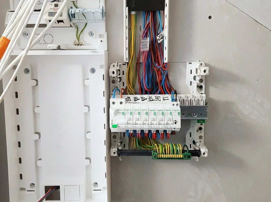 Tableau électrique en cours d'installation, fixé au mur