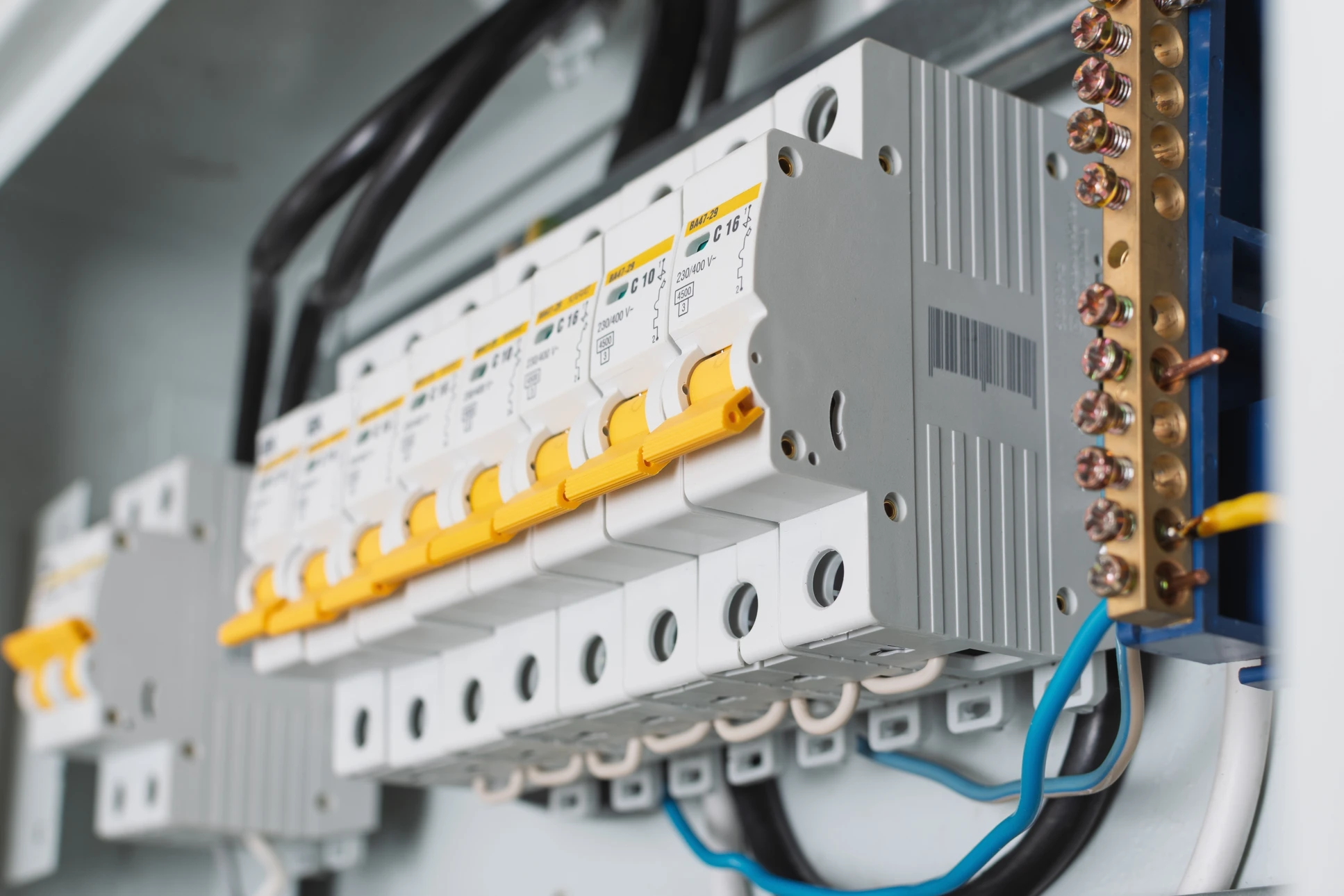 Photographie r&eacute;aliste d'un &eacute;lectricien professionnel en train d'installer ou de travailler sur une installation &eacute;lectrique dans un int&eacute;rieur r&eacute;sidentiel en r&eacute;novation. L'&eacute;lectricien porte des &eacute;quipements de s&eacute;curit&eacute; appropri&eacute;s et travaille sur des &eacute;l&eacute;ments &eacute;lectriques visibles (c&acirc;blage, tableaux &eacute;lectriques, prises, ou installation de fils). L'arri&egrave;re-plan montre un chantier de r&eacute;novation int&eacute;rieure avec murs en cours de finition, mettant en avant &agrave; la fois le m&eacute;tier principal d'&eacute;lectricien et le contexte de r&eacute;novation compl&egrave;te de la maison.