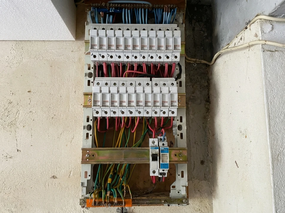 Un &eacute;lectricien effectue des mesures &eacute;lectriques dans un tableau de distribution int&eacute;rieur