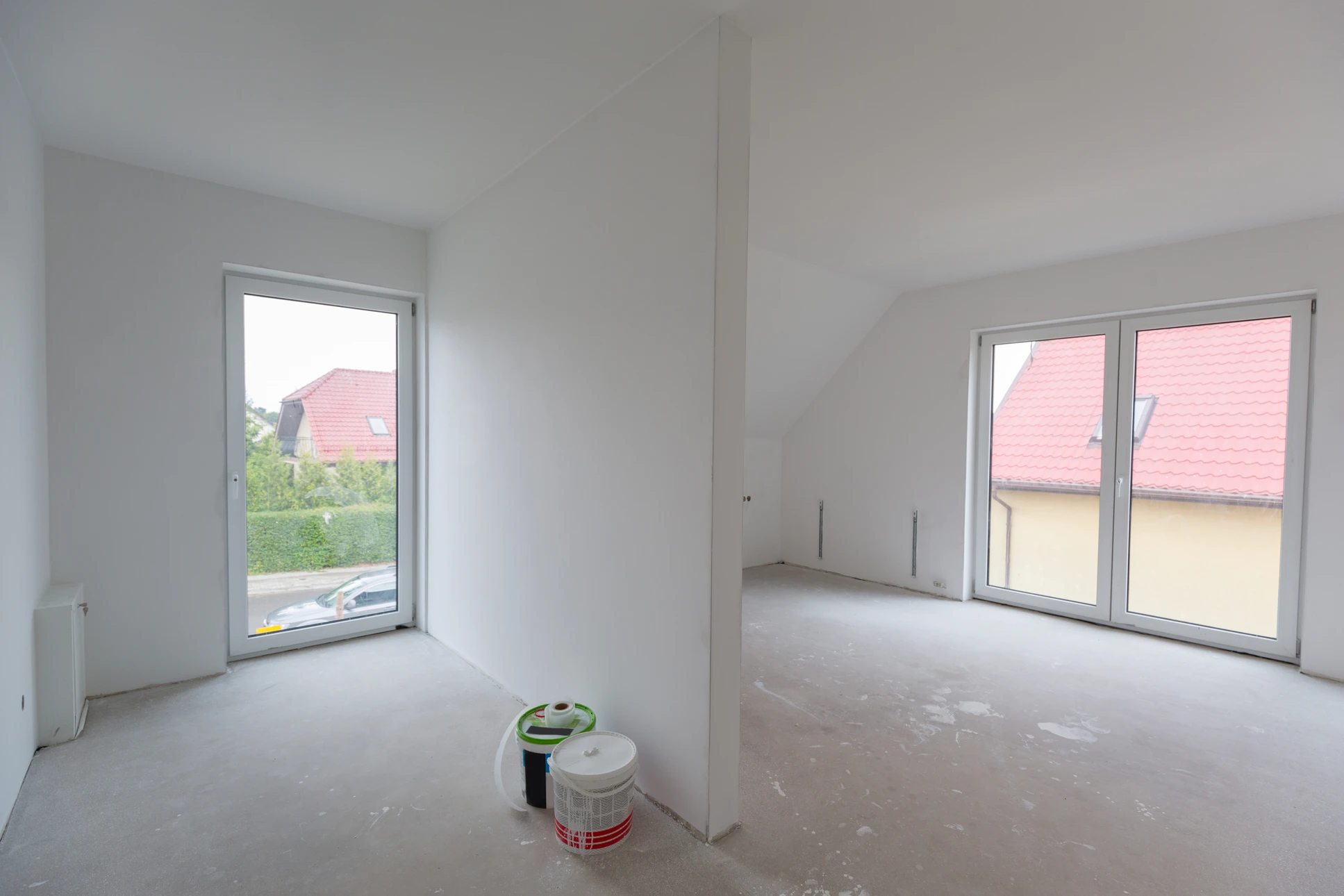 Deux ouvriers du bâtiment installent un faux plafond en plaques de plâtre dans un espace intérieur en construction