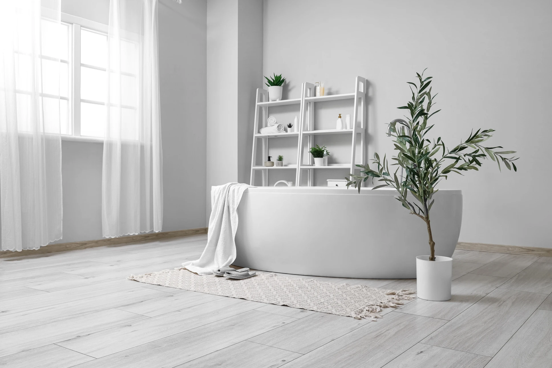 Intérieur de salle de bain en rénovation avec ouvrier appliquant du joint sur carrelage mosaïque