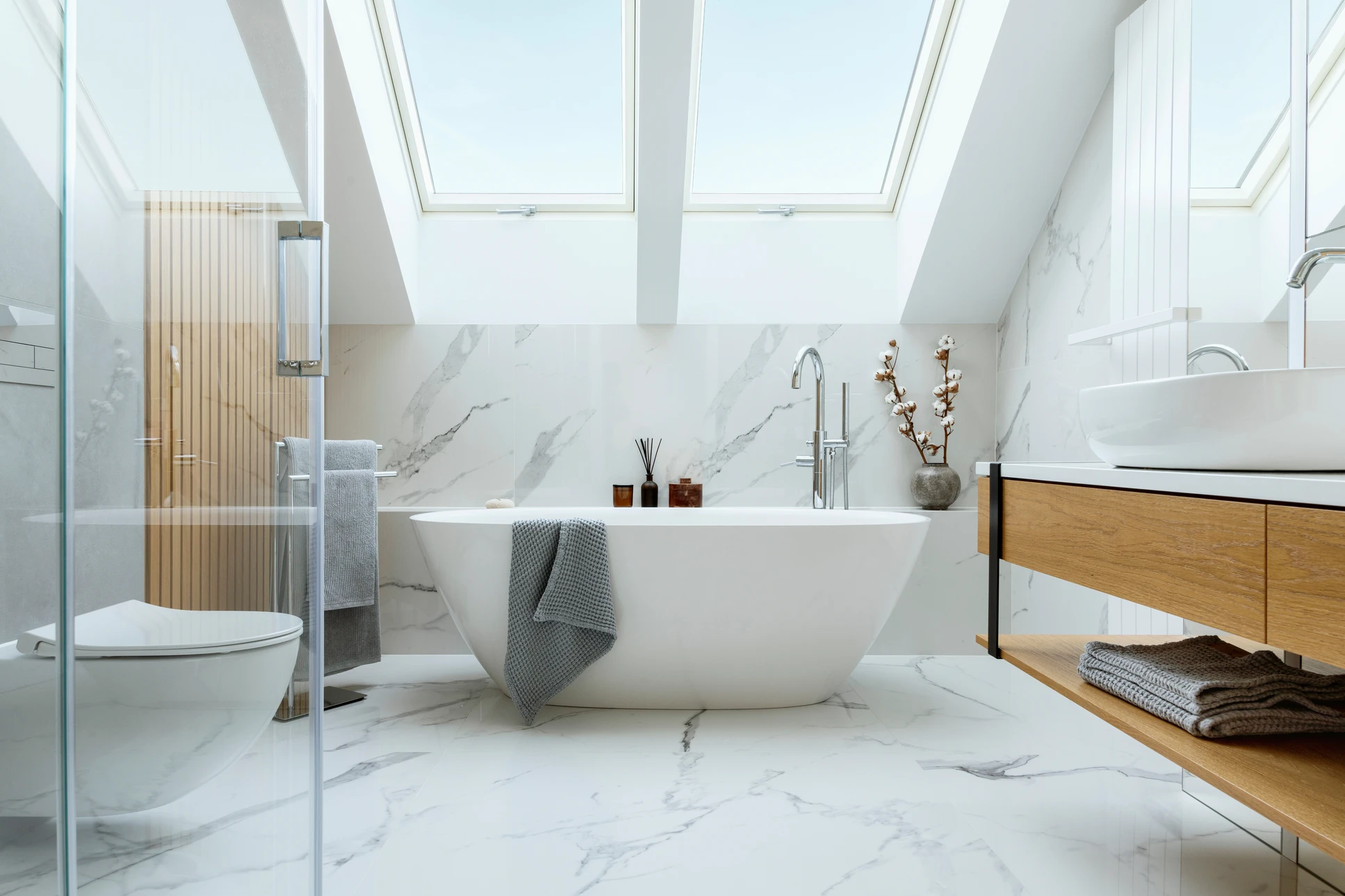 Salle de bain moderne avec baignoire îlot blanche ovale, mur bleu marine, parquet bois naturel